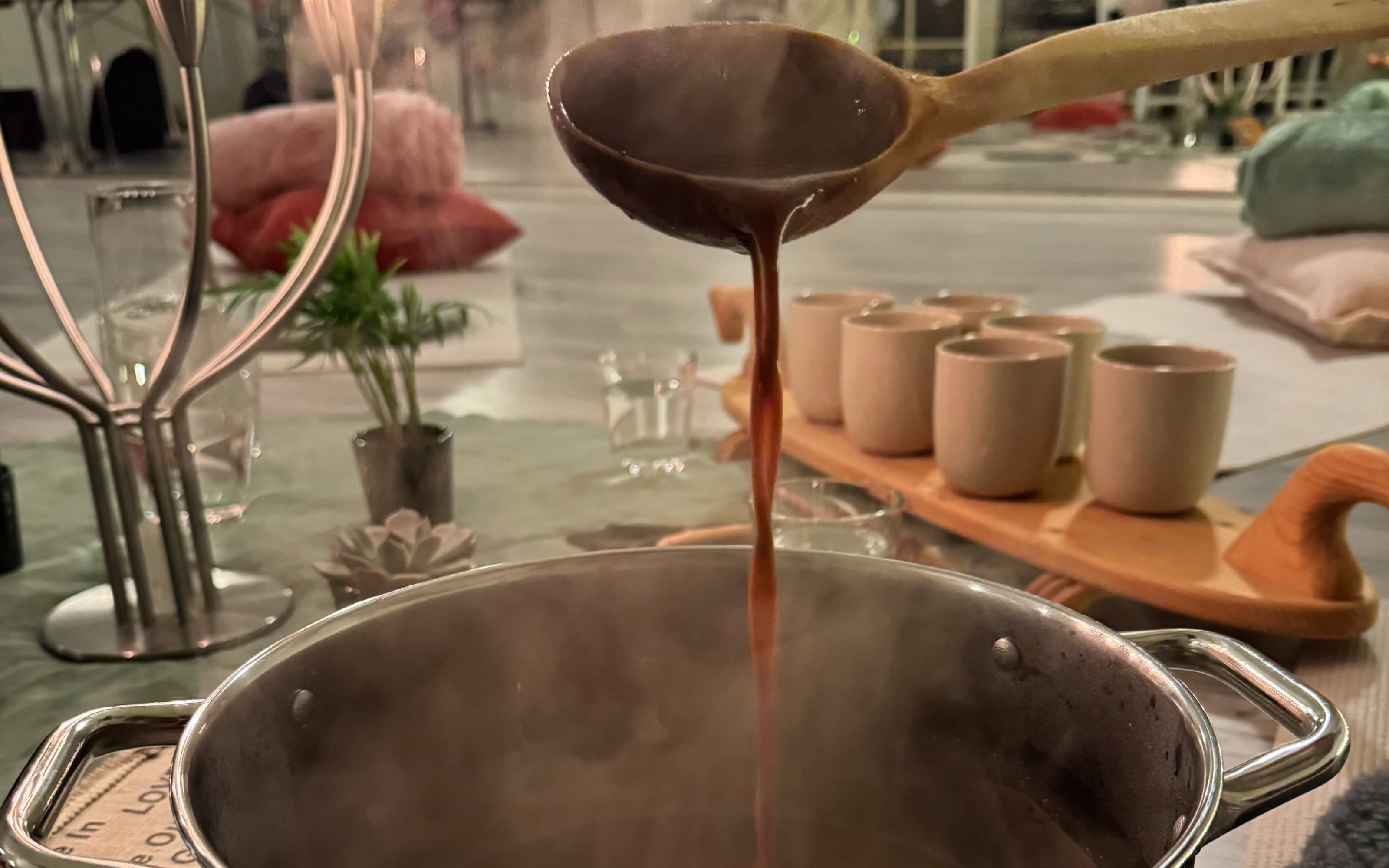 Close-up of a dandelion seed head with delicate white fibers against a blurred green background.