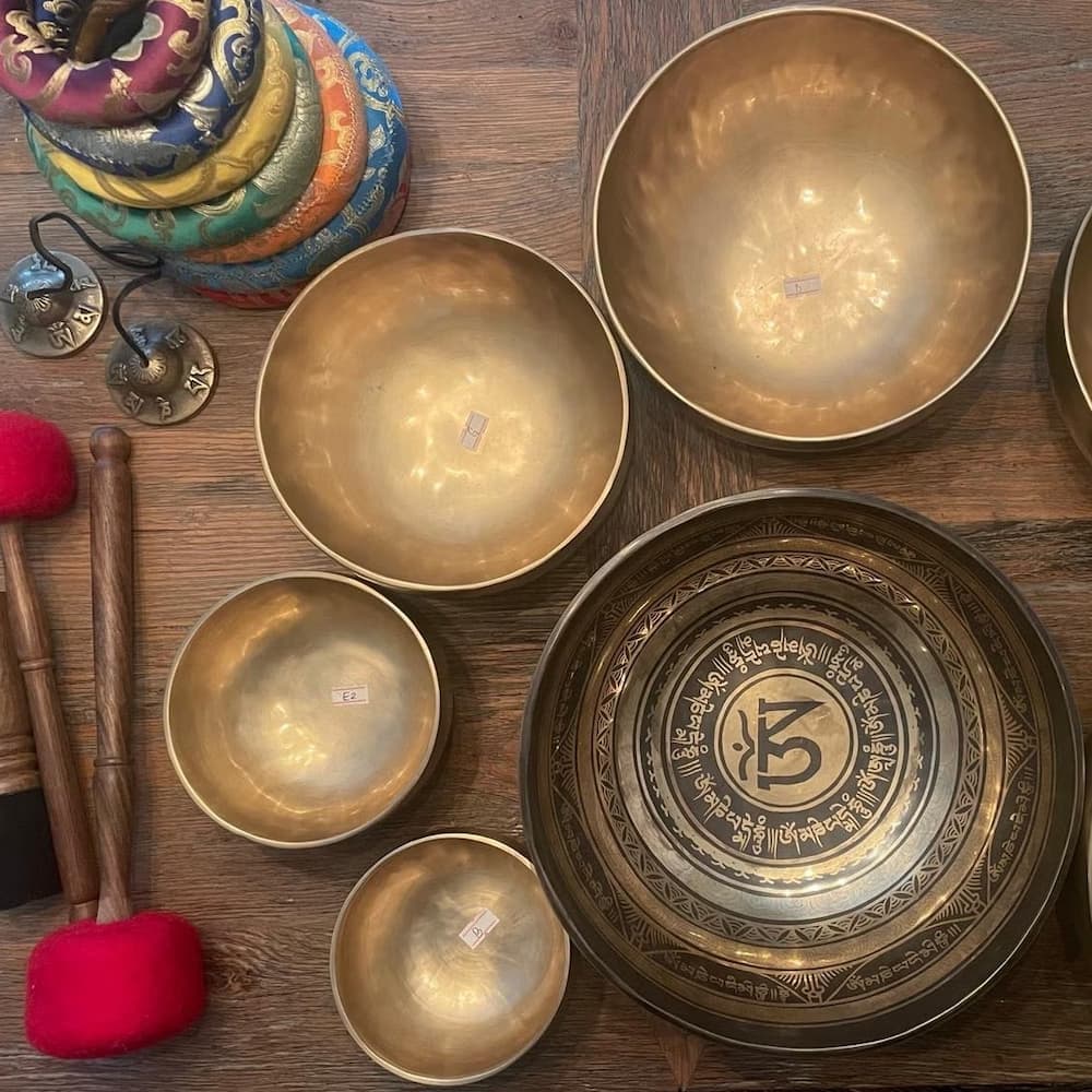 Close-up of a dandelion seed head with delicate white fibers against a blurred green background.